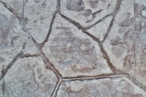 Stamped concrete mosaic patterns, earth tone colors and textures from directly above. A procedure of stamping cement to resemble tile, wood or other materials.