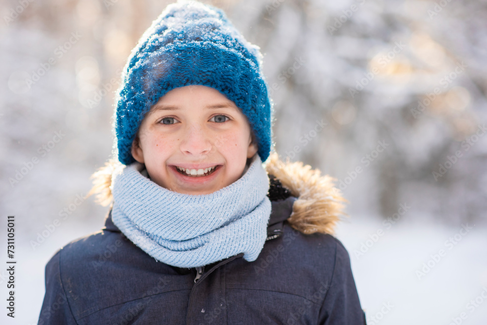 portrait of a happy 11 year old European boy with gray eyes, wearing a hat and knitted scarf, snowy winter, outside portrait of a happy 11 year old European boy with gray eyes, wearing a hat and knitted scarf, snowy winter, outside