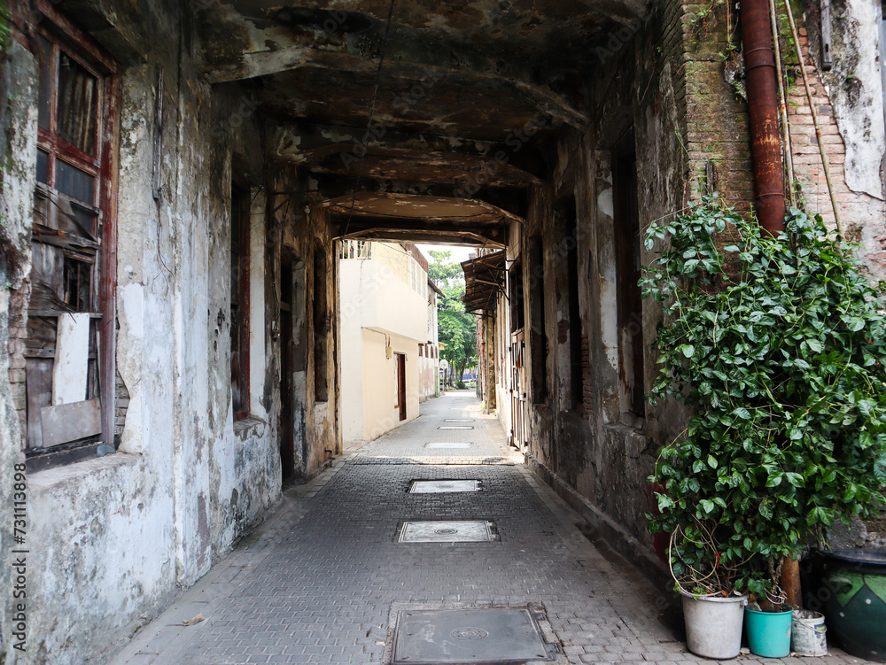 an alley with a small tunnel leading to the street. surabaya, indonesia - 4 january 2024