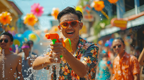 Close up happy Young man asian having fun using water gun During the Songkran Festival on Khaosan Road, Bangkok, Thailand photo