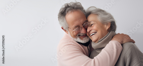 Un couple senior, heureux, amoureux, riant et partageant un moment de bonheur intense, arrière-plan gris, image avec espace pour texte.