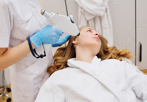 procedure of hardware skin rejuvenation using a cold stream of carbon dioxide CO2. A cosmetologist performs a skin rejuvenation procedure for an attractive woman