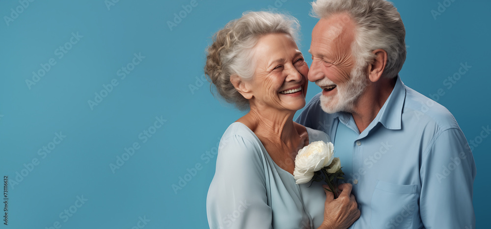 Un couple senior, heureux, amoureux, riant et partageant un moment de bonheur intense, arrière-plan bleu, image avec espace pour texte. - obrazy, fototapety, plakaty 