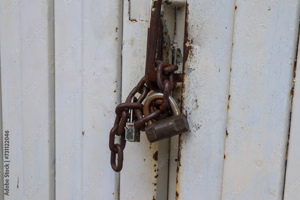 close up of the padlock and chain locking the door. surabaya, indonesia - 4 january 2024 close up of the padlock and chain locking the door. surabaya, indonesia - 4 january 2024