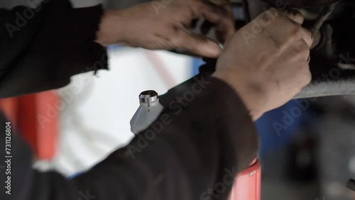 Ball joint replacement in a car. Hand of Auto Mechanic or Car Mechanic Tighten Upper Arm Ball Joint Nut in Car or Auto Repair Shop
