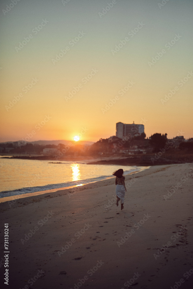 running on beach at sunset with cityscape in background. running on beach at sunset with cityscape in background.