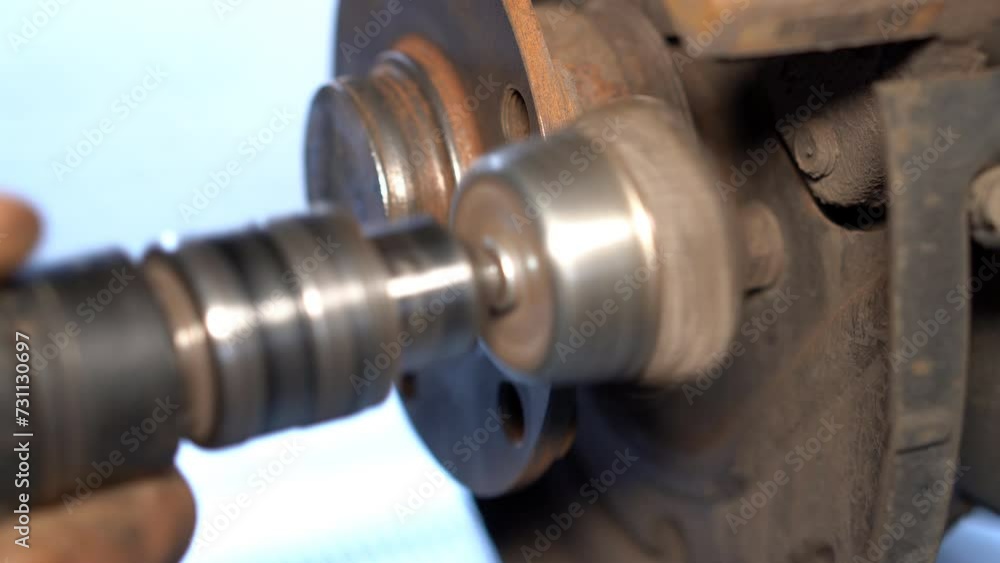 Restoring a car chassis in a car service center. An auto mechanic restores an old car chassis, cleaning it from metal corrosion. Restoring a car chassis in a car service center. An auto mechanic restores an old car chassis, cleaning it from metal corrosion.