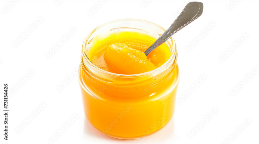 Jar of orange puree for babies or children with a spoon inside isolated on white background Jar of orange puree for babies or children with a spoon inside isolated on white background