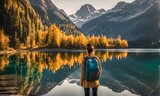 Backpack-adorned girl standing at edge of serene mountain lake