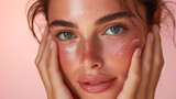 Young woman with youthful and glowing skin. Applying cream to the face. Skincare routines.