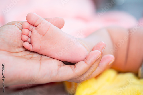 Banner. Mother holding in the hands feet of newborn baby. Baby feet in mother hands. Tiny Newborn Baby's feet on female Shaped hands closeup.