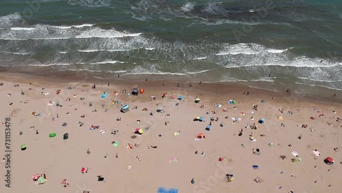 Aerial view of unrecognizable people sunbathing in the free beach of Riccione, Romagna coast, Rimini, Italy photo