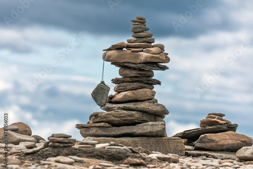 A stack of pebbles on a beach, Cape Enrage Nature Reserve, Bay of Fundy, New Brunswick, Canada. Tourists leave their mark by building these stone cairns. photo