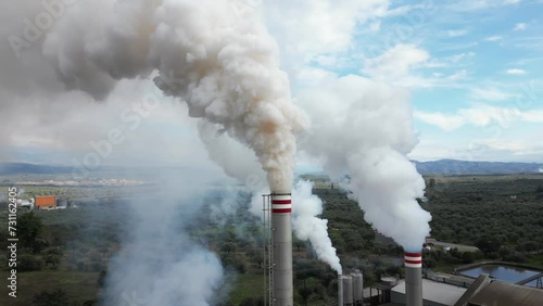 atmospheric pollution and emission of combustion fumes gas released into the air from a factory - chimney emits fine dust smog - Climate change and global warming concept - flue drone aerial view  