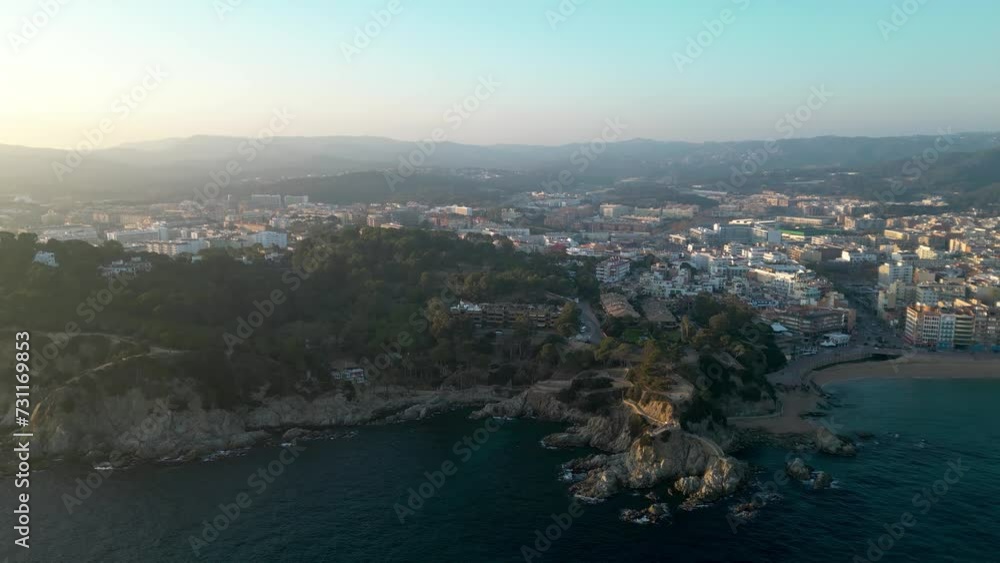 Cinematic aerial view of Lloret del Mar city, at sunset. Travel destination in Spain and one of the most famous beaches from Catalonia. Drone tracking right. Panoramic view of all city Cinematic aerial view of Lloret del Mar city, at sunset. Travel destination in Spain and one of the most famous beaches from Catalonia. Drone tracking right. Panoramic view of all city
