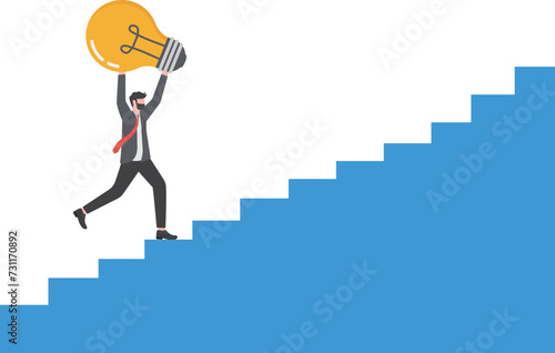 Solution and success concept.businessman holding a light bulb walking up the stairs

