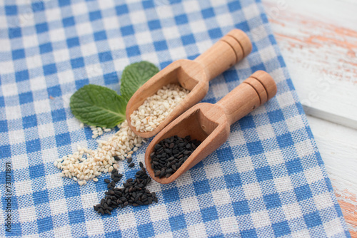 sesame seeds in a bowl on a wooden background. Seasoning for cooking