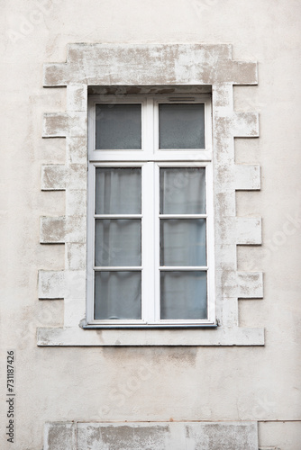 Facade with windows in an old tenement house in France, French architecture.