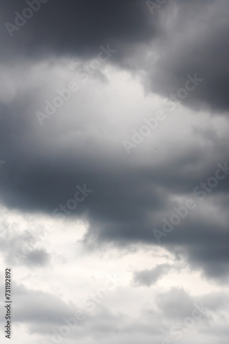 Black clouds in bright blue sky closeup