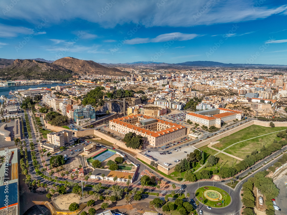 Fototapeta premium Aerial view of Cartagena port city in Spain surrounded by bastions and fortifications, medieval castle hill, roman amphitheater, bull ring, 