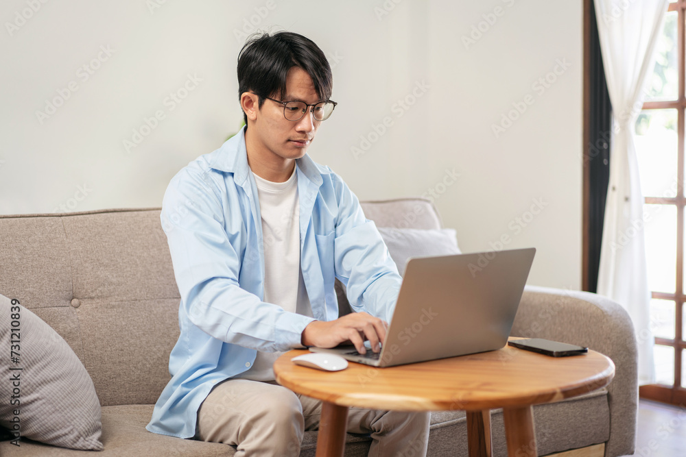Businessman in casual is sitting comfortable sofa to thoughtful of idea for new business while using laptop Businessman in casual is sitting comfortable sofa to thoughtful of idea for new business while using laptop