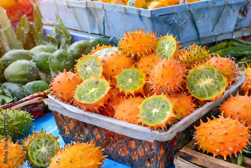 A vibrant display of freshly picked kiwano, glistening under the sun, ready for sale. African Spiny Melon, African Cucumber, Fruit of Paradise, Milu, Mino, Kiwuano, and Kiwano photo