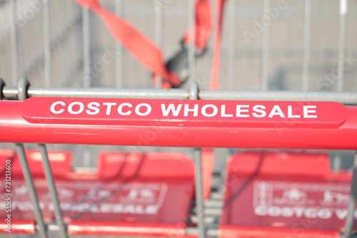 costco wholesale red silver shopping cart close up on costco wholesale writing caption text on handle close up in summer middle of frame