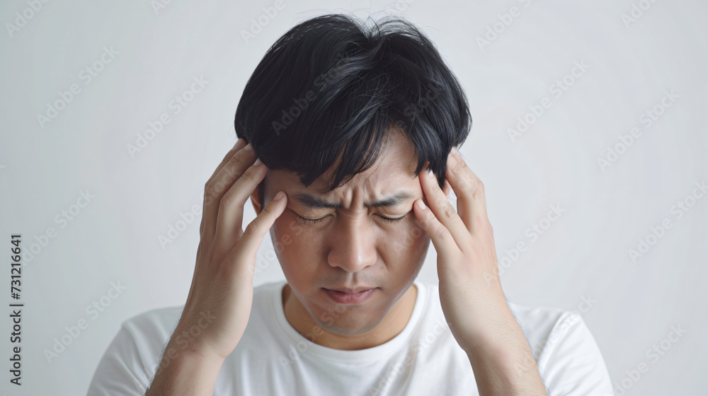 asian man with a headache holding his head in pain asian man with a headache holding his head in pain
