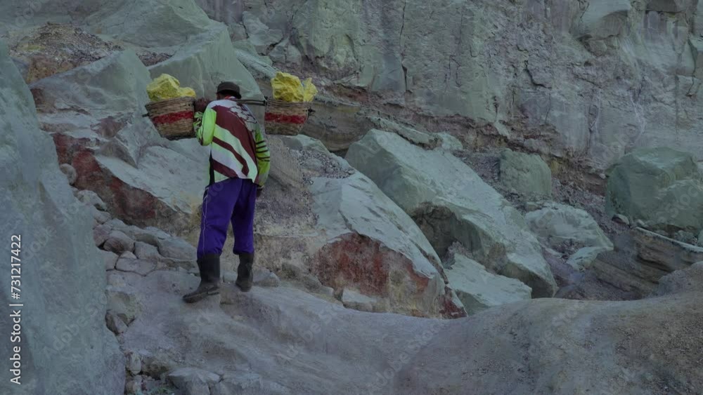 Miner carrying baskets of sulphur mined from Kawah Ijen volcano, Java, Indonesia Miner carrying baskets of sulphur mined from Kawah Ijen volcano, Java, Indonesia