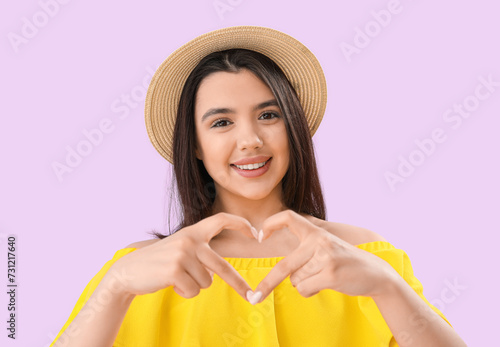 Young woman making heart wi...