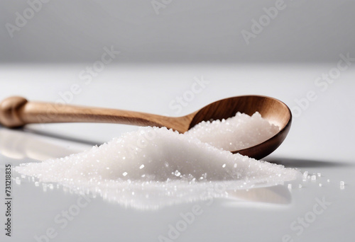 Pile sugar crystal with wooden spoon isolated on white