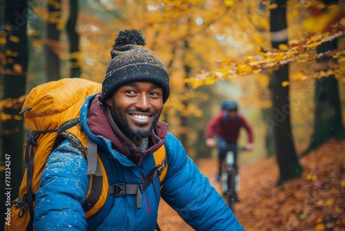 A joyous man wearing a jacket and a smile, cycling through the autumn forest on a peaceful fall day, surrounded by towering trees and embracing the outdoor beauty photo