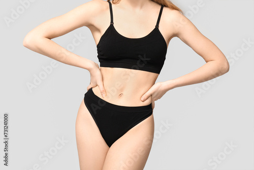 Sexy young woman in black cotton underwear on light background © Pixel-Shot