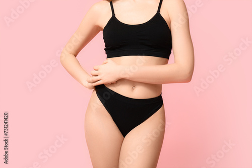 Sexy young woman in black cotton underwear on pink background