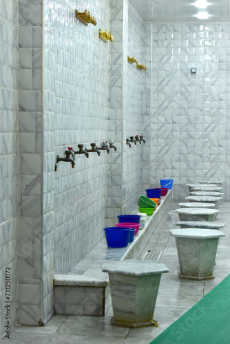 A special place for washing feet before entering the mosque, with water taps and coloured buckets. © Klara Bakalarova