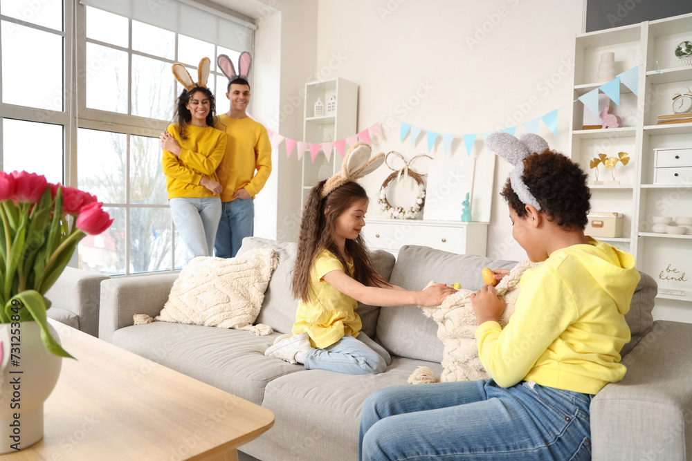 Little children searching for Easter eggs on sofa at home Little children searching for Easter eggs on sofa at home