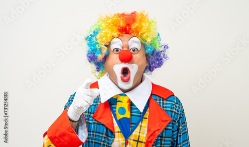 Mr Clown. Portrait of Funny comedian face Clown man in colorful uniform wearing wig standing pointing finger to camera. Happy expression amazed face male bozo in various pose on isolated background.