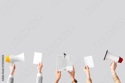 Hands holding ballot box, voting papers and megaphones on white background. Election concept