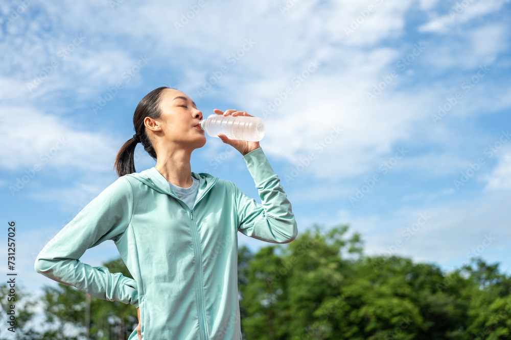 Happy slim asian woman drinking water after workout exercising on running track at sport stadium. Young beautiful asian drinking water after jogging running outdoor. Healthy and active lifestyle. Happy slim asian woman drinking water after workout exercising on running track at sport stadium. Young beautiful asian drinking water after jogging running outdoor. Healthy and active lifestyle.