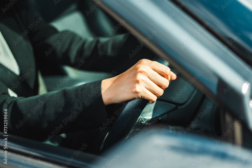 Young woman getting new car hand is holding the steering wheel of the car Safe driving in the downtown city. Young woman getting new car hand is holding the steering wheel of the car Safe driving in the downtown city.