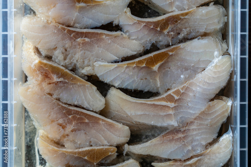 Sliced herring in oil sauce closeup, top view