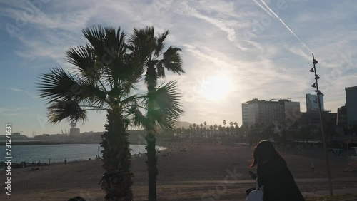 Palm tree and girl against the backdrop of Barcelona beach photo