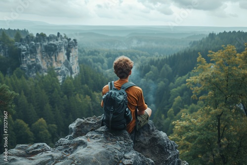 Travel photogrrapher on a top of a mountain and enjoying the view