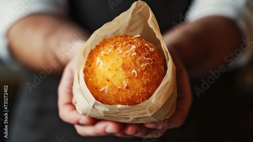 Arancini balls in craft paper bag in the man's arms photo