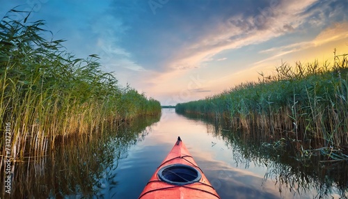 kayak among reeds on evening river