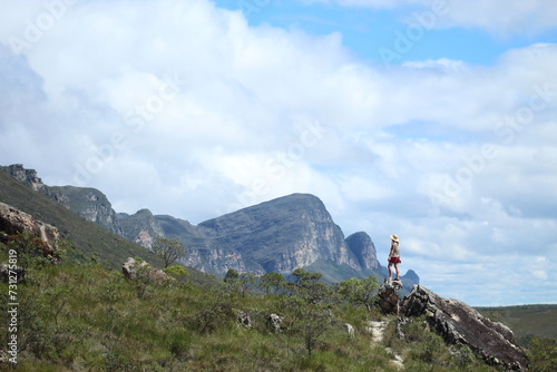 mulher em trilha na Chapada Diamantina, Bahia, com motanhas ao fundo © carina furlanetto