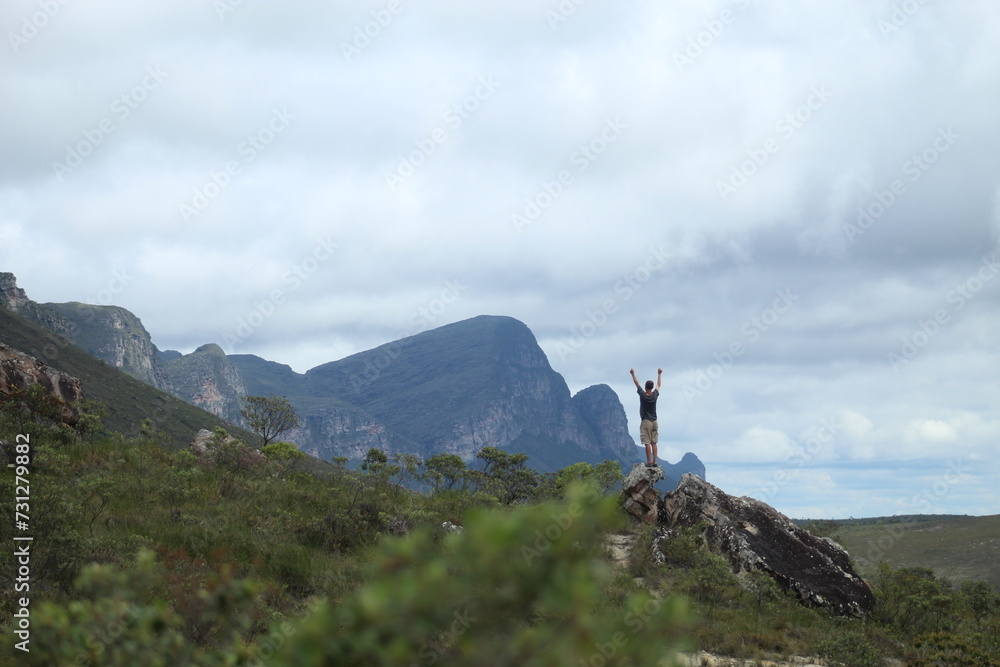 homem em trilha na Chapada Diamantina, Bahia, com motanhas ao fundo