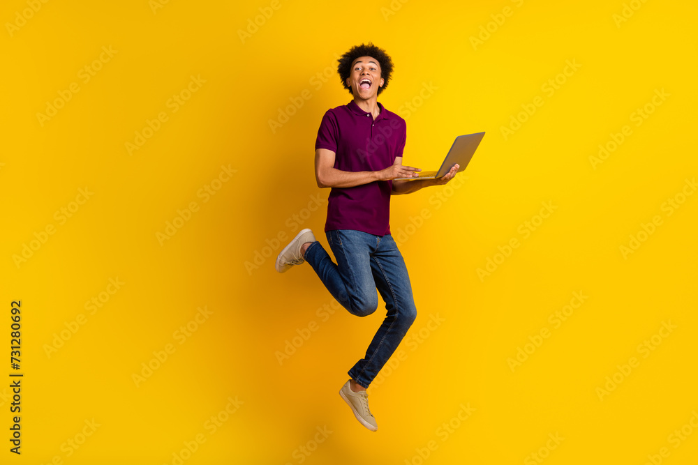 Photo of cheerful man wear stylish magenta clothes use modern device fly air rejoice seasonal offer isolated on yellow color background
