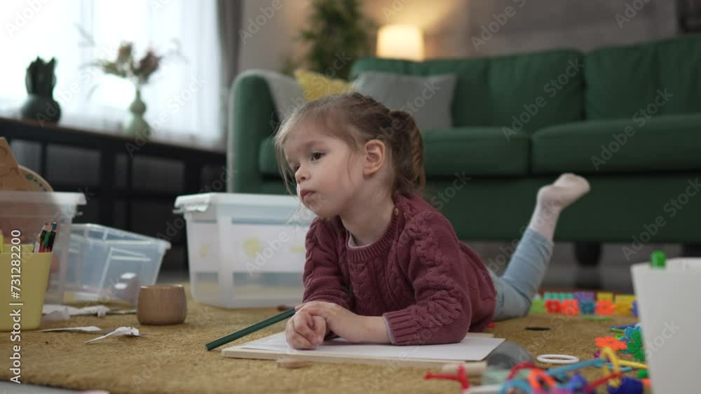 One girl caucasian toddler play on the floor at home draw with pen One girl caucasian toddler play on the floor at home draw with pen