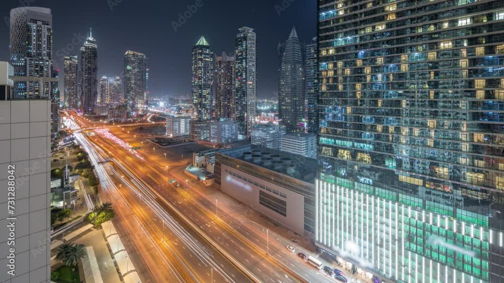Business bay district skyline with modern architecture timelapse day to night transition after sunset from above. Aerial panorama of Dubai skyscrapers, towers near main highway. Traffic on crossroad Business bay district skyline with modern architecture timelapse day to night transition after sunset from above. Aerial panorama of Dubai skyscrapers, towers near main highway. Traffic on crossroad